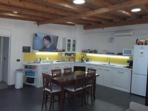 a kitchen with a table and a tv on the wall at La Casa di Luigi in Catania