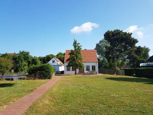 una casa blanca con un patio con una pelota de fútbol en Authentisches Inselhaus - ideal für Kiter/Surfer/Familien, en Fehmarn