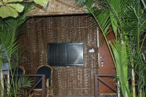 a room with a tv on a wall with plants at Sea Shades Palolem Resort in Palolem