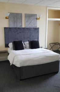 a bedroom with a large bed with a blue headboard at The Devonshire House Hotel in Liverpool