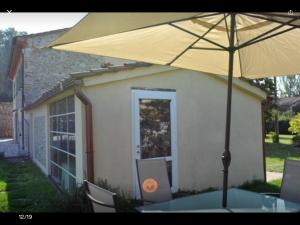 una mesa con sombrilla frente a una casa en casamariu en Lucca