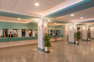 un hall avec des plantes en pot dans un bâtiment dans l'établissement htop Royal Star & SPA #htopFun, à Lloret de Mar