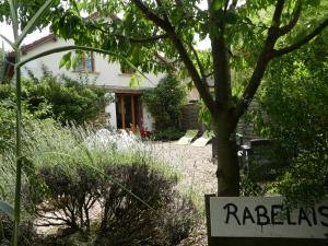 una casa con un cartel delante de un patio en Les chaumières du Chêne, en Pouillé