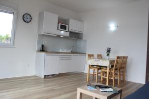 a living room with a kitchen and a table with chairs at Villa Marina in Omiš