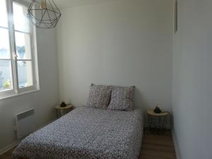 een kleine slaapkamer met een bed en een raam bij Appartement les Elfes in Capbreton