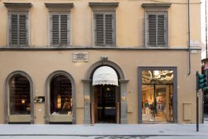 a building with arches and windows on a street at Room Mate Collection Isabella, Florence in Florence
