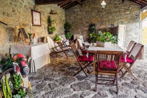 a room with a table and chairs and a stone wall at Casa do Varandão in Barcelos