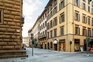 a city street with buildings and people walking down the street at Room Mate Collection Isabella, Florence in Florence