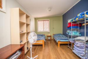 a room with two bunk beds and a fan at The Gee Beach House in Guilderton