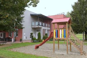 a playground with a slide in front of a house at Penzion Letališče in Murska Sobota