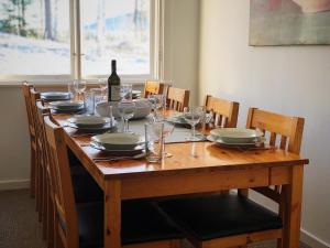 ein Holztisch mit einer Flasche Wein und Gläsern in der Unterkunft Vildmarks Lodge in Ytterhogdal