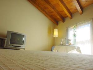 a bedroom with a bed and a tv and a window at El Mirador de las Monjas in Trujillo
