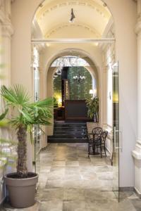 an entrance to a building with a palm tree at Hotel Grand Hedonist in Pančevo