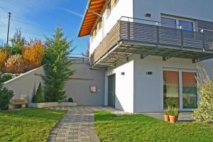 een huis met een balkon en een loopbrug bij Schmid's Ponyhöfle in Friedrichshafen