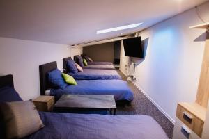 ミエレツにあるNOCLEGI HOSTEL CENTRUM MIELECのベッド4台とテレビが備わるホテルルームです。