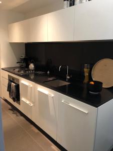 a kitchen with white cabinets and a sink and a stove at Fantastic Southbank Apartment in Melbourne