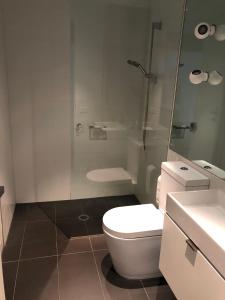 La salle de bains est pourvue de toilettes et d'une douche en verre. dans l'établissement Fantastic Southbank Apartment, à Melbourne