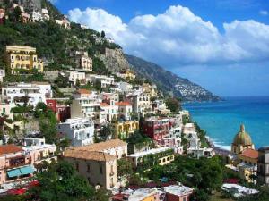 eine Gruppe von Gebäuden auf einem Hügel neben dem Meer in der Unterkunft Villaverde in Positano