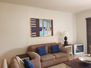 sala de estar con sofá y TV en Point Village Accommodation - Portobello 26 en Mossel Bay