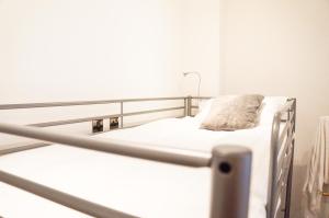 cama de hospital con sábanas blancas y almohada en The Mornington Camden Female only Hostel, en Londres
