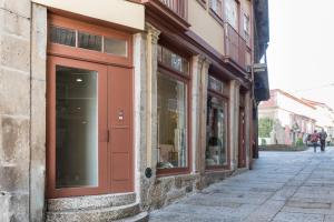 eine rote Tür auf einem Gebäude auf einer Straße in der Unterkunft Casa da Cera da Porta da Vila in Guimarães