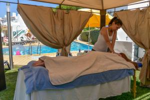 a woman laying on top of a bed next to a tent at Verde Pino in Vilamoura