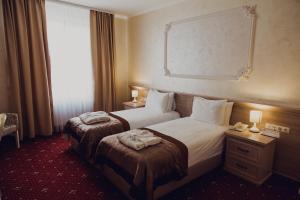 a hotel room with two beds and a window at Hotel France in Vinnytsya