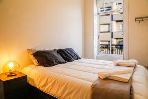 a bedroom with a large bed with a window at METRO APARTMENT in Porto