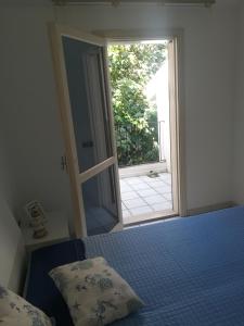 een slaapkamer met een bed en een open deur bij Casa TREND in Marina di Ragusa
