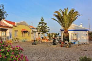 a house with a palm tree in front of it at Villa Ana Margarida Beach in Ericeira