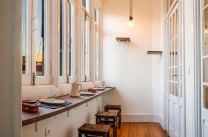 a room with a long counter with chairs and windows at METRO APARTMENT in Porto