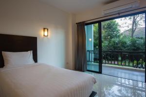 a bedroom with a bed and a large window at Wilacha Chiang Rai in Chiang Rai