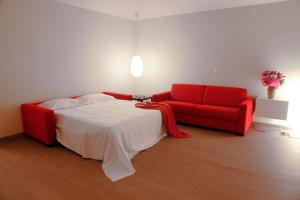 a bedroom with a bed and a red couch at Casa Natalì in Matera