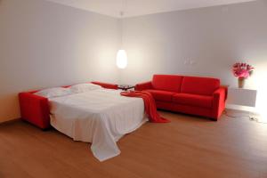マテーラにあるカーサ ナタリのベッドルーム1室(ベッド1台、赤いソファ付)