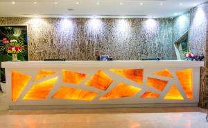 een receptie in de lobby van het hotel met oranje en gele kunstwerken bij Hotel Rockdale in Visakhapatnam