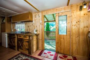 cocina con paredes de madera y puerta a un porche en Eden en Sędziszowa