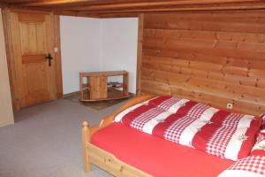 レンクにあるChalet Weissenbergの木製の壁のベッドルーム1室(ベッド1台付)
