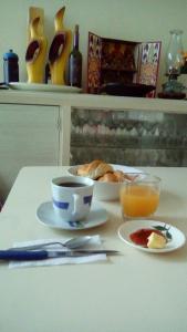 a table with a cup of coffee and a plate of food at Hospedaje Casa Viru in Lima +145 photos