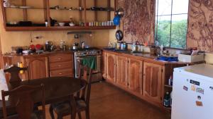 a kitchen with wooden cabinets and a table in it at Welcoming vibes in Treasure Beach