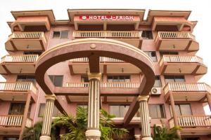 a tall pink building with a hotel sign on it at Hotel Jfrigh in Kampala