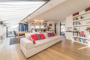 una sala de estar con un sofá blanco con almohadas rojas en Torlonia Exclusive Penthouse en Roma