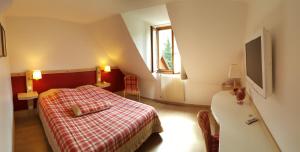 a bedroom with a bed and a dresser at Hotel Les Remparts in Kaysersberg