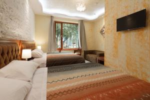a hotel room with two beds and a flat screen tv at Art Plaza Boutique Hotel in Quito +59 photos