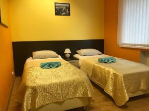 two beds in a room with yellow walls at Гостевой дом Альянс in Velikiy Novgorod