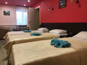a hotel room with three beds with towels on them at Гостевой дом Альянс in Velikiy Novgorod
