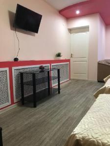 a room with a bed and a tv on a wall at Гостевой дом Альянс in Velikiy Novgorod