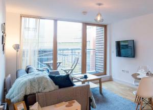 a living room with a couch and a large window at Modern 2 Bedroom Apartment in City Centre with Balcony in Manchester