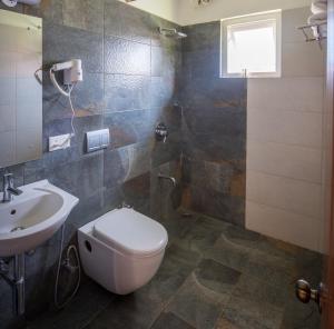 a bathroom with a toilet and a sink at The Realm in Coonoor