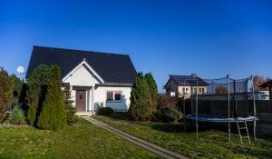 a house with a trampoline in the yard at Wyspa Uznam - DOMEK KARSIBÓR in Karsibór