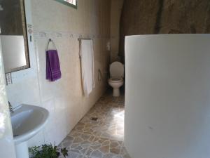 a bathroom with a white toilet and a sink at chale pouso da mariposa in Praia Vermelha